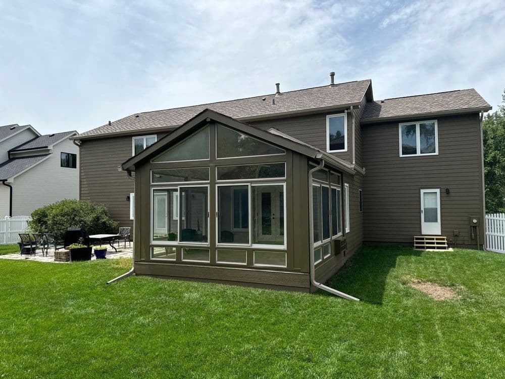 Modern home with large screened porch and backyard patio, perfect for outdoor living.